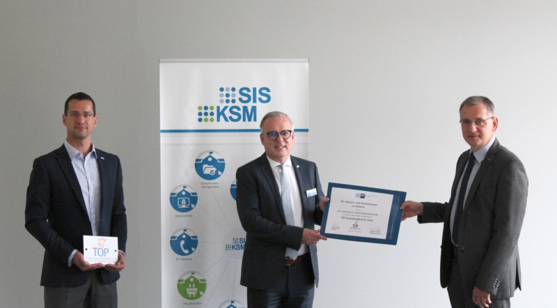 Geschäftsbereichsleiter der IHK übergibt Auszeichnung an Geschäftsführung der SIS